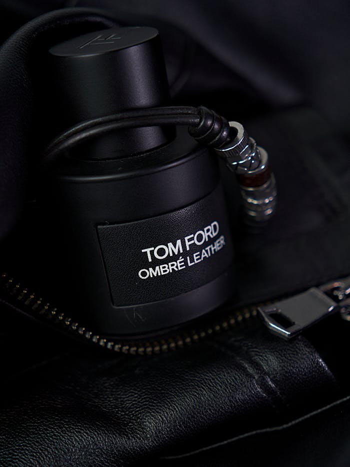 Tom Ford Ombré Leather fragrance bottle placed stylishly on a black leather jacket.